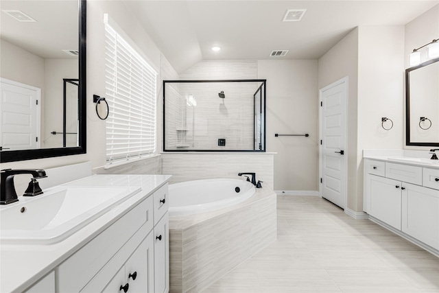 full bath featuring a garden tub, two vanities, visible vents, a stall shower, and a sink