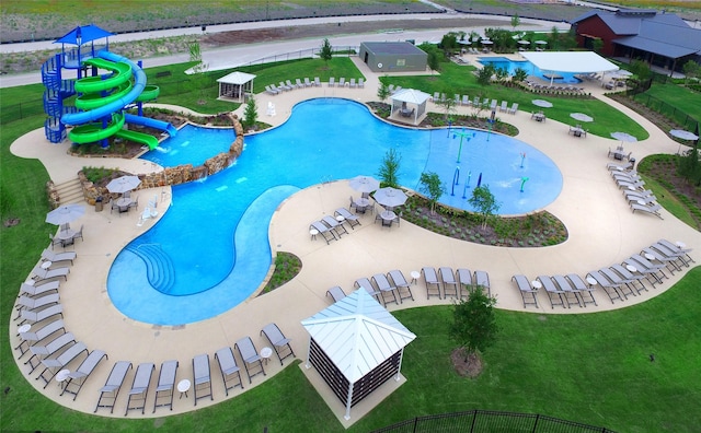 view of pool with playground community, a lawn, and a water slide