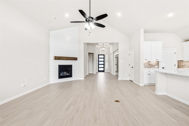 unfurnished living room featuring visible vents, baseboards, a ceiling fan, light wood-type flooring, and a fireplace