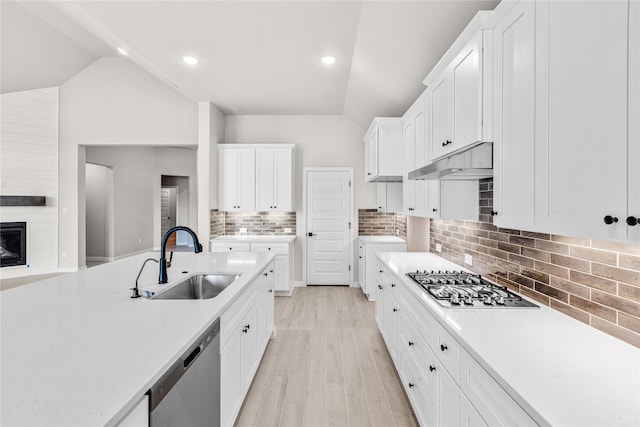 kitchen featuring under cabinet range hood, stainless steel appliances, a sink, white cabinetry, and light countertops