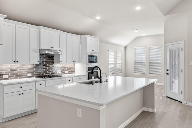 kitchen featuring under cabinet range hood, a kitchen island with sink, and white cabinets