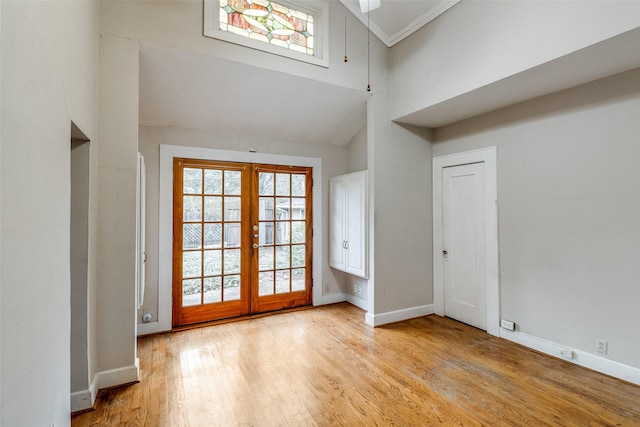 interior space featuring light wood-type flooring, french doors, plenty of natural light, and baseboards