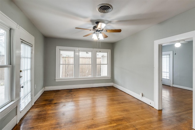 unfurnished room featuring visible vents, baseboards, and wood finished floors