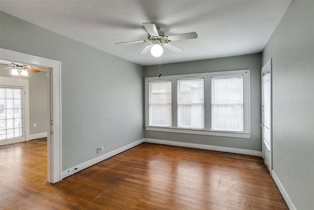 unfurnished room featuring baseboards, a ceiling fan, and wood finished floors