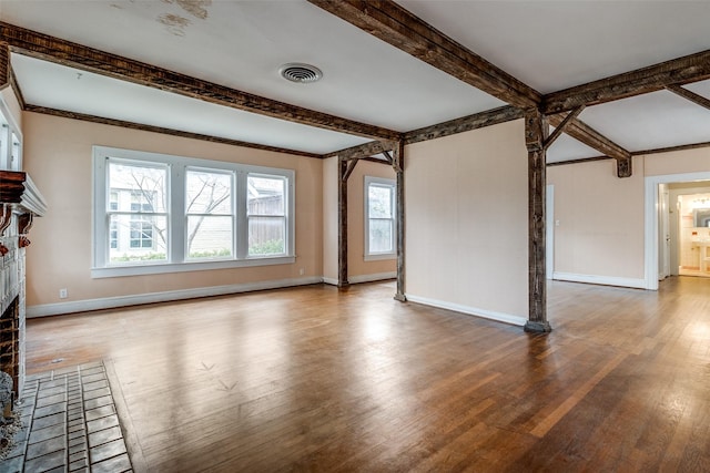 unfurnished living room featuring a fireplace, wood finished floors, visible vents, baseboards, and beamed ceiling