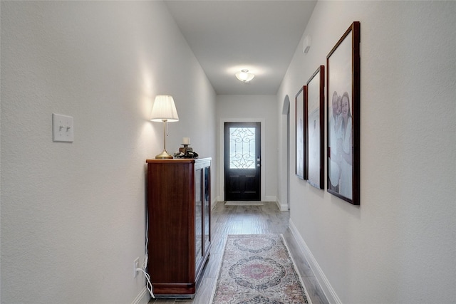 doorway to outside featuring light wood-style flooring and baseboards