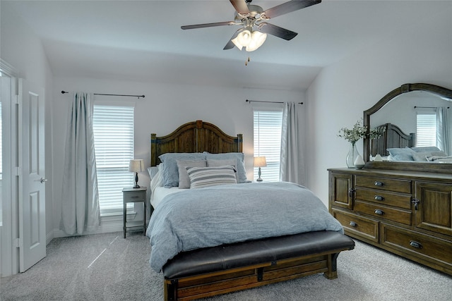 bedroom with light carpet, ceiling fan, multiple windows, and vaulted ceiling