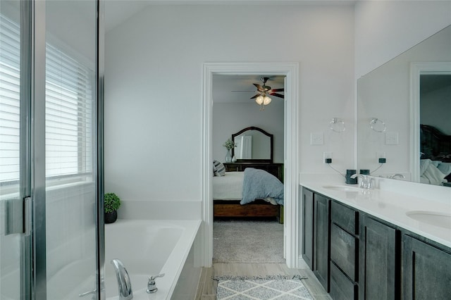 full bath featuring a garden tub, double vanity, connected bathroom, vaulted ceiling, and a sink