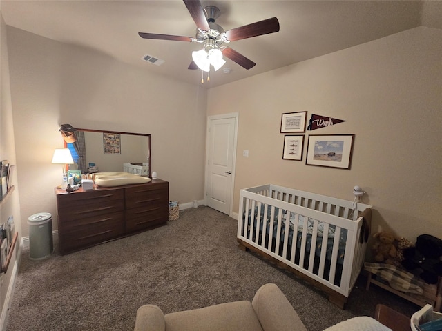 bedroom with carpet floors, visible vents, baseboards, a ceiling fan, and a crib