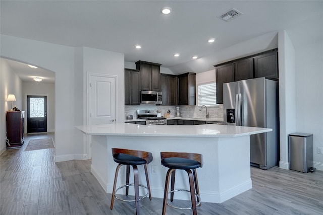 kitchen featuring visible vents, light countertops, appliances with stainless steel finishes, backsplash, and a center island