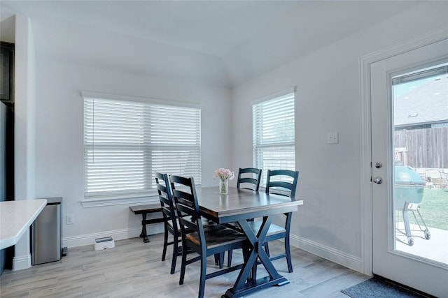 dining space featuring light wood-type flooring, plenty of natural light, and baseboards