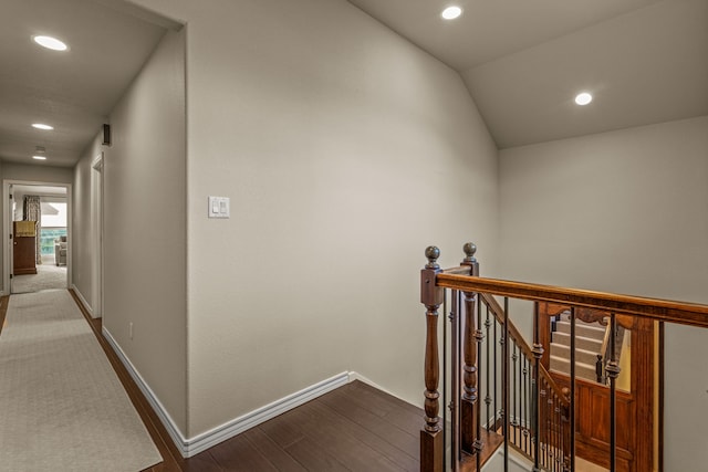 hallway with recessed lighting, baseboards, an upstairs landing, and wood finished floors