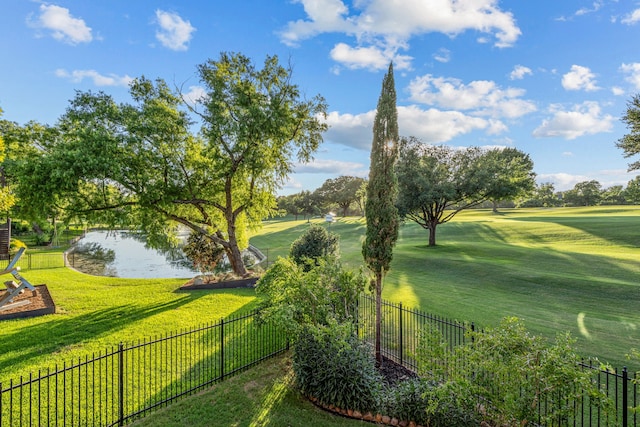 view of property's community featuring a water view, fence, and a yard