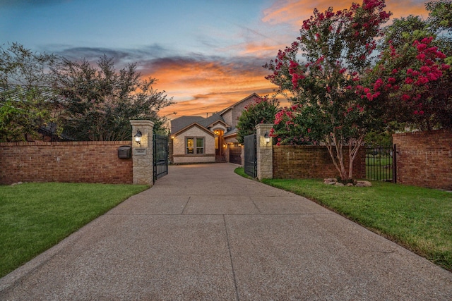 view of gate with a fenced front yard and a lawn