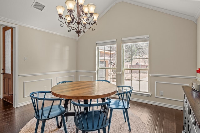 dining area with visible vents, lofted ceiling, ornamental molding, dark wood-type flooring, and an inviting chandelier