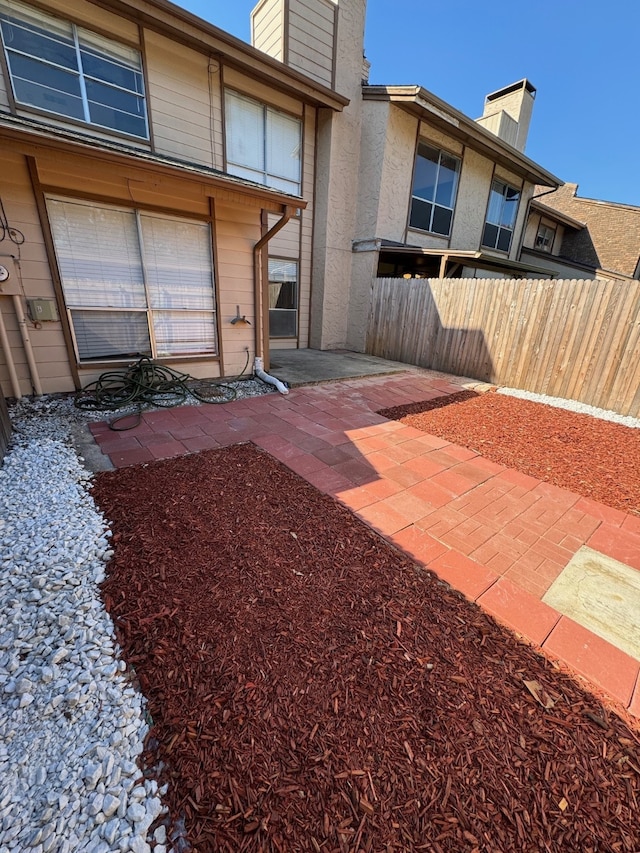 exterior space featuring a patio, a chimney, and fence