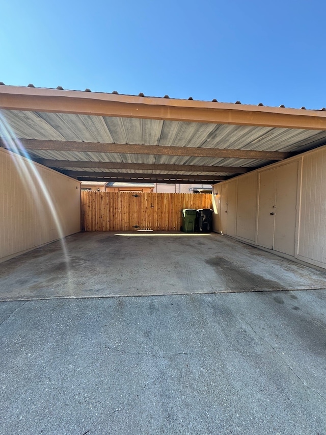 view of parking / parking lot featuring a carport and fence