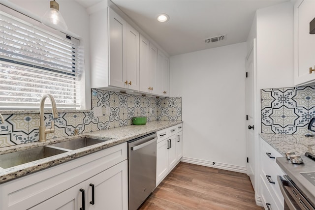 kitchen featuring white cabinets, dishwasher, and a sink