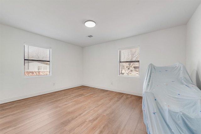 unfurnished bedroom with visible vents, light wood-style flooring, and baseboards