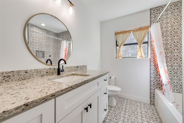 bathroom featuring tile patterned flooring, toilet, vanity, baseboards, and shower / bath combo