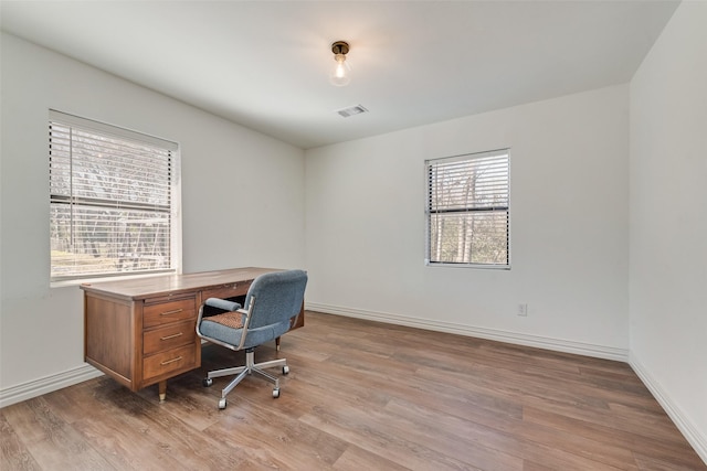 office space featuring light wood-style floors, visible vents, and baseboards