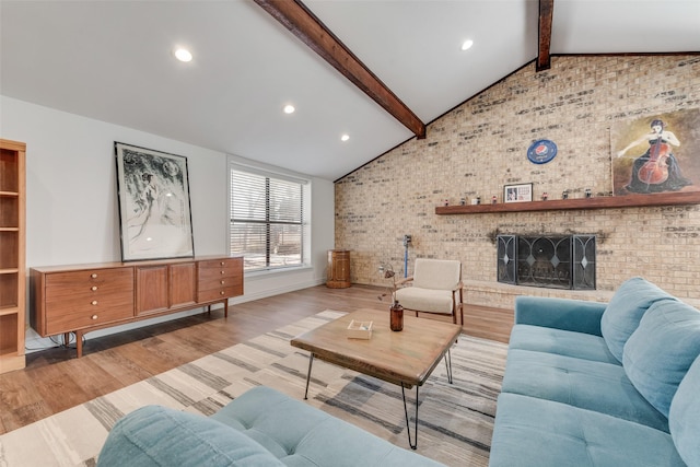 living area with lofted ceiling with beams, recessed lighting, brick wall, a brick fireplace, and light wood finished floors