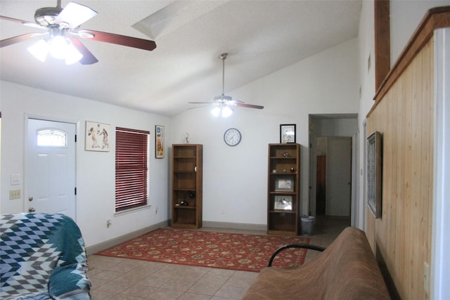 living area featuring lofted ceiling, baseboards, and a ceiling fan