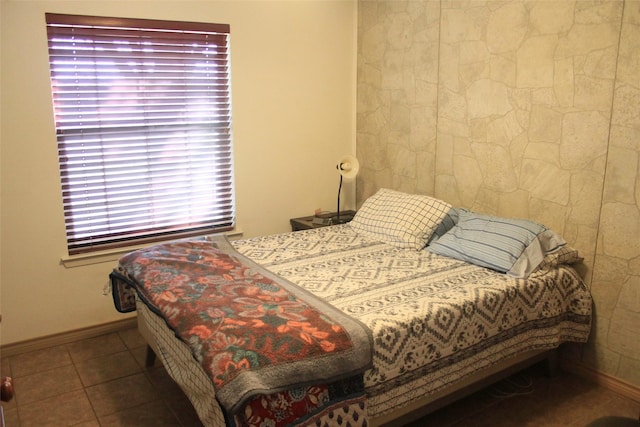 bedroom with baseboards and tile patterned floors