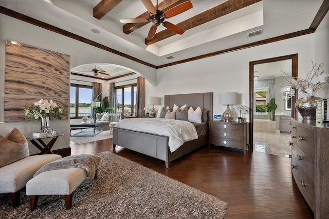 bedroom with arched walkways, ensuite bathroom, visible vents, dark wood-style floors, and a raised ceiling