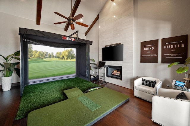 living area with golf simulator, beam ceiling, a fireplace, dark wood-type flooring, and high vaulted ceiling