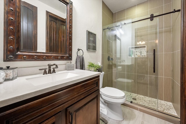 full bath featuring toilet, a shower stall, and vanity