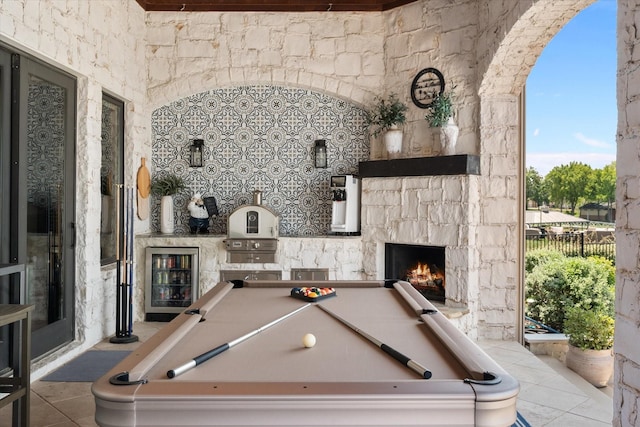 playroom with beverage cooler, pool table, an outdoor stone fireplace, and tile patterned floors