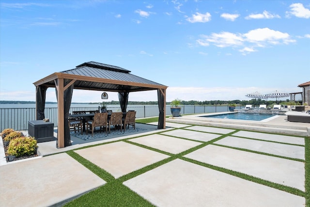 view of patio / terrace featuring a water view, fence, a fenced in pool, and a gazebo