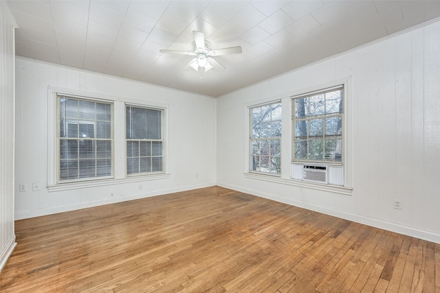 empty room with light wood-style floors, cooling unit, baseboards, and a ceiling fan