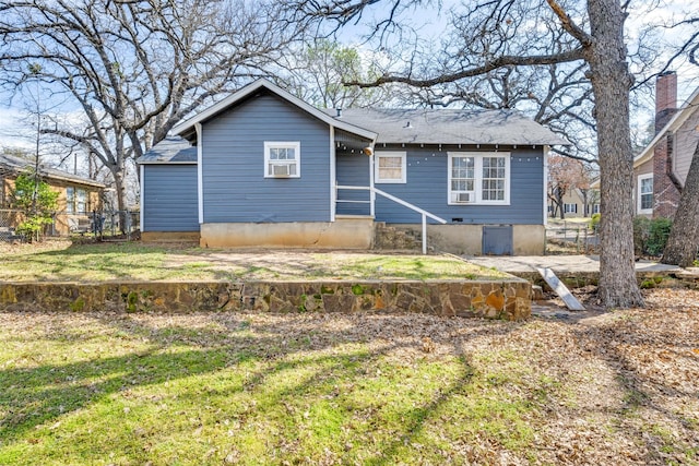 view of front of property with fence, cooling unit, and a front yard