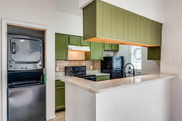 kitchen with stacked washer and clothes dryer, under cabinet range hood, black appliances, green cabinets, and backsplash