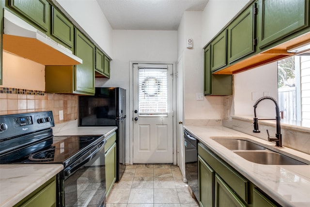 kitchen featuring plenty of natural light, under cabinet range hood, black appliances, green cabinets, and a sink