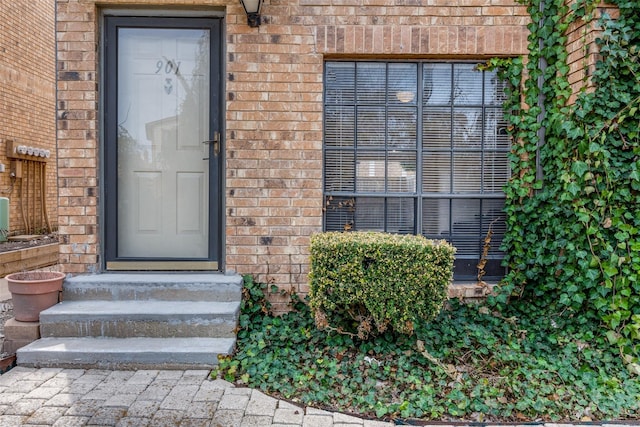 property entrance featuring brick siding