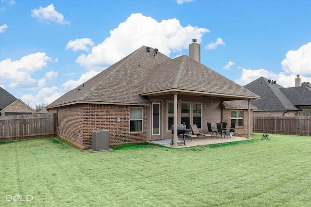 back of house featuring a fenced backyard, central AC, and a yard