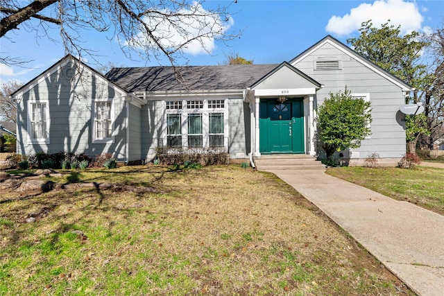 view of front of home featuring a front lawn and roof with shingles