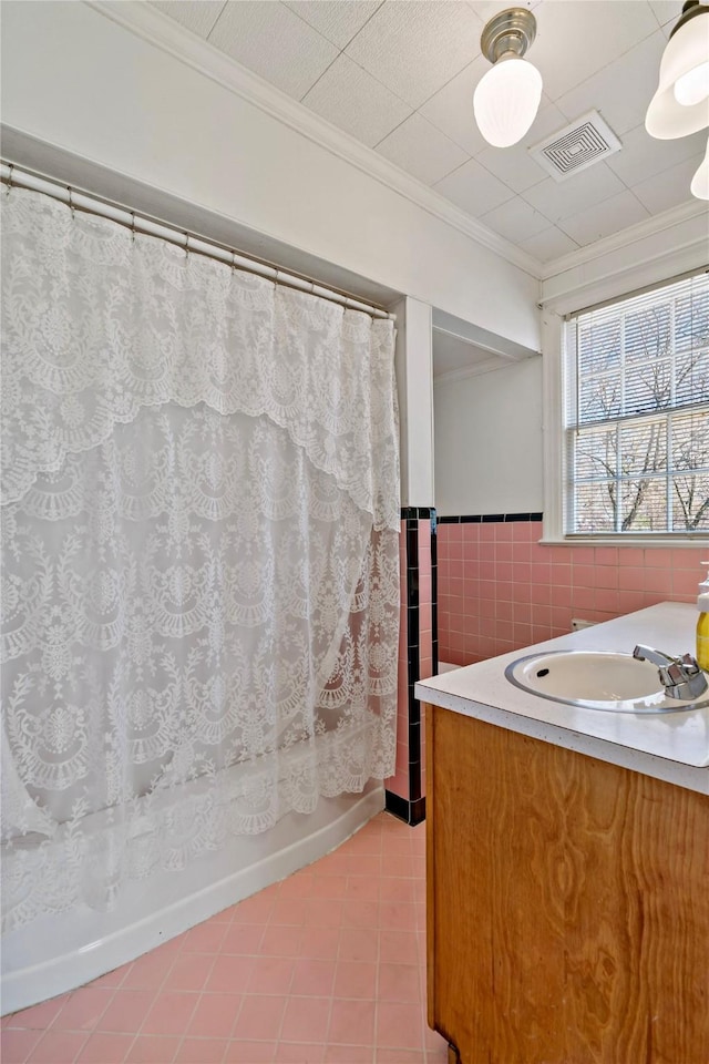 full bathroom featuring a wainscoted wall, tile walls, visible vents, ornamental molding, and vanity