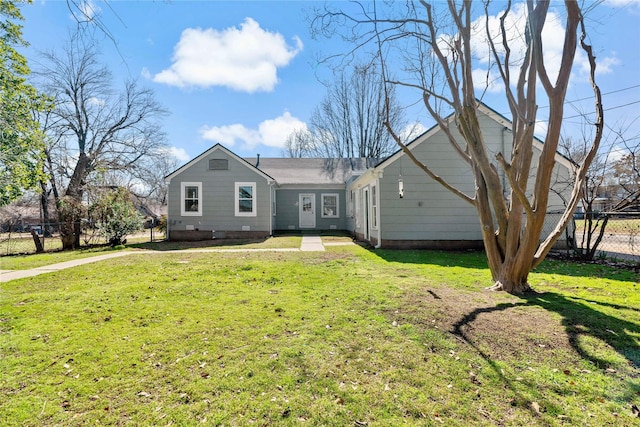 ranch-style home featuring a front lawn and fence