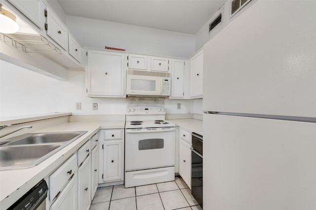 kitchen with light tile patterned flooring, white appliances, a sink, white cabinets, and light countertops