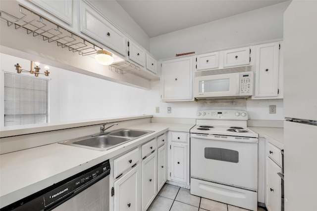 kitchen featuring light tile patterned floors, white appliances, a sink, white cabinets, and light countertops