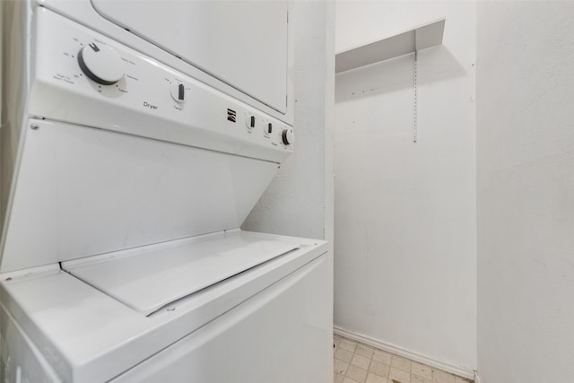 clothes washing area with laundry area, light floors, and stacked washer / drying machine