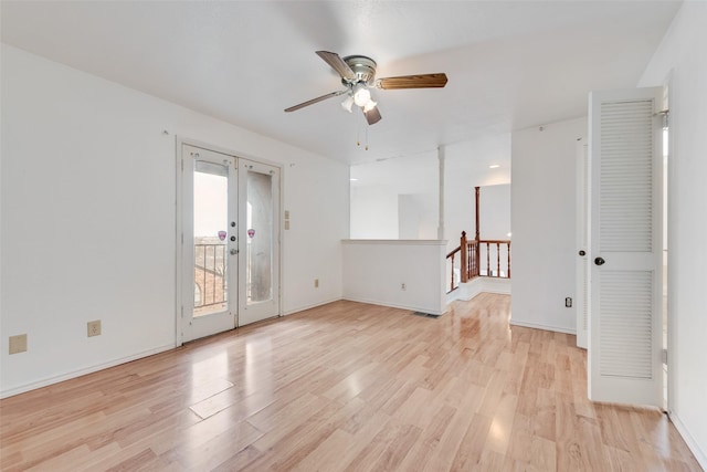 spare room featuring baseboards, french doors, and light wood-style floors