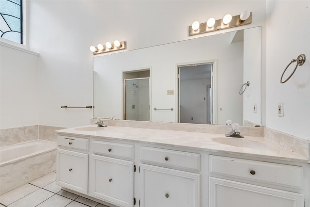 full bathroom featuring double vanity, a stall shower, a sink, and tile patterned floors