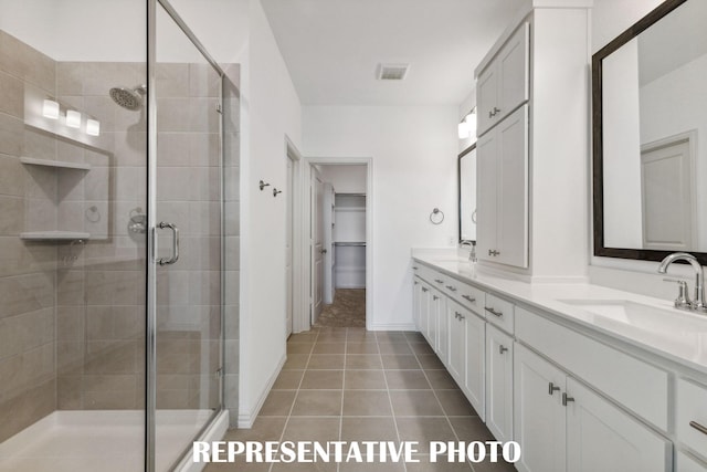 full bathroom with a shower stall, a spacious closet, and a sink