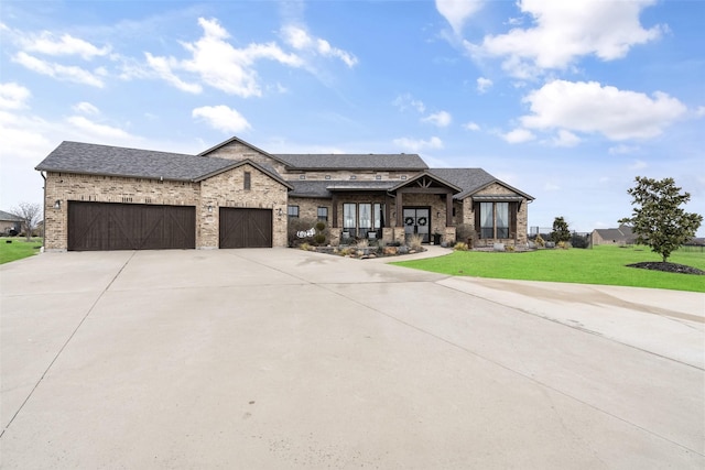 view of front of home featuring a garage, a shingled roof, concrete driveway, a front yard, and brick siding