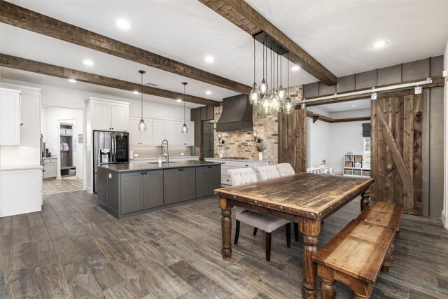 3200 W Fm 455, Celina, TX 75009 - kitchen featuring a barn door, a sink, white cabinets, custom exhaust hood, and decorative light fixtures